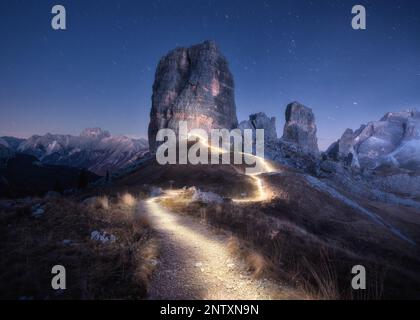 Taschenlampe Wanderwege auf Bergpfad gegen hohe Felsen in der Nacht Stockfoto