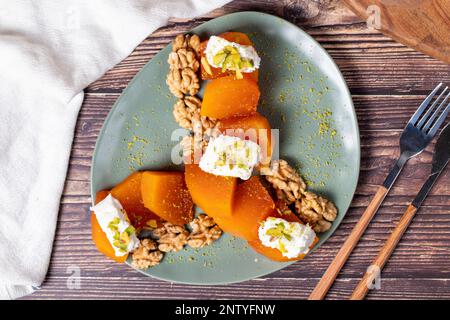 Cremiges Kürbis-Dessert. Süße türkische Ramadan-Delikatessen. Kürbis-Dessert mit Sorbet auf grauem Hintergrund. Draufsicht Stockfoto