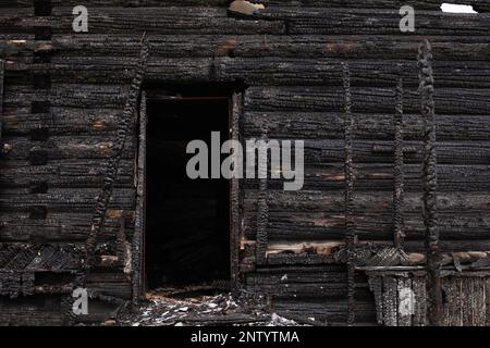 Verbranntes Holzhaus, schwarze Reste von Bauarbeiten Stockfoto