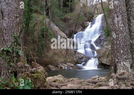 Vertikaler Wasserfall im Valle del Jerte bei Winterbaumwurzeln langzeitiger Exposition Stockfoto