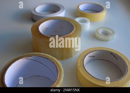 Scotch Bänder, doppelseitiges Klebeband, Abdeckband und Gewebeband auf Rollen isoliert auf weißer Oberfläche Stockfoto
