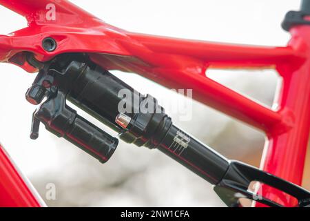 Seitenansicht eines hinteren Stoßdämpfers eines modernen Mountainbikes am hinteren Hilfsrahmen. Luftschock auf einem Fahrrad. Stockfoto