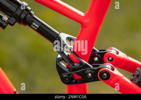 Seitenansicht eines hinteren Stoßdämpfers eines modernen Mountainbikes am hinteren Hilfsrahmen. Luftschock auf einem Fahrrad. Stockfoto
