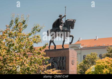 Statue von Kralj Tomislav in zagreb, seitlicher Blick über einen blauen Himmel an einem sonnigen Tag mit viel Laub. Stockfoto