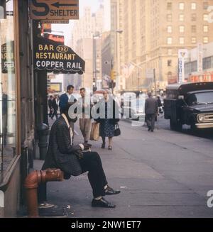 USA New York 1964. Eine Straßenszene mit einem Mann, der vorne sitzt und raucht. Kredit Roland Palm Ref. 5-39-6 Stockfoto