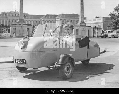 In den 1950er Jahren. Eine Frau auf dem Fahrersitz eines dreirädrigen Miniwagens, hergestellt vom österreichischen Autohersteller Felber. Dieses Modell wurde in den Jahren 1952 bis 1953 in 4000 Einheiten hergestellt. Mit einem 350-ccm-Motor mit einem Gewicht von 280 kg. August 1952 Stockfoto