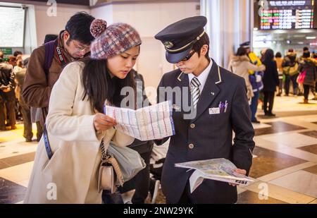 Tokyo Station, Reisende sprechen mit einem Mitarbeiter in der Haupthalle, Marunouchi, Tokyo, Japan Stockfoto