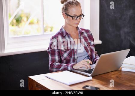 Beschäftigt, beschäftigt, beschäftigt Eine kurze Aufnahme einer schönen jungen Frau, die von zu Hause aus arbeitet. Stockfoto