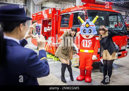 Feuerwehrmann unter Bild von zwei Mädchen mit einem Maskottchen der Feuerwehr, während Dezomeshiki oder Neujahr Parade durch das Tokyo Fire Department, Tokio, Japa Stockfoto