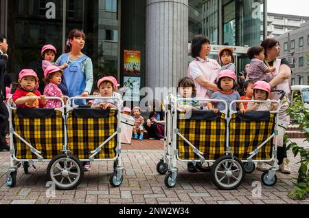 Kinder warten Blick Sanno Matsuri Parade, nahe dem Bahnhof Ichigaya. Die Parade beginnt und endet am HieJinja-Schrein, Nagata-cho.Tokyo Stadt, Ja Stockfoto