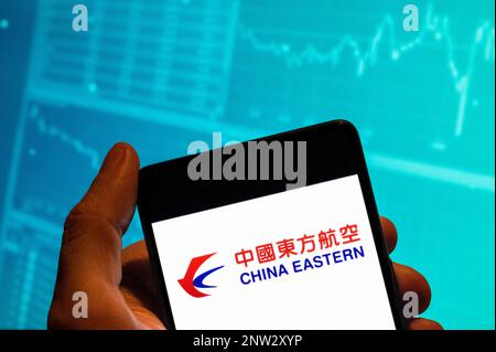 China. 15. Februar 2023. In dieser Fotoabbildung wird das Logo der Fluggesellschaft China Eastern auf einem Smartphone mit einer Grafik des Börsenindex im Hintergrund angezeigt. (Kreditbild: © Budrul Chukrut/SOPA Images via ZUMA Press Wire) NUR REDAKTIONELLE VERWENDUNG! Nicht für den kommerziellen GEBRAUCH! Stockfoto