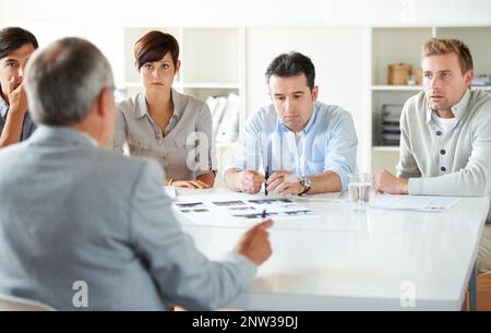 Um den Besprechungstisch. Ausgeschnittene Aufnahme eines laufenden Geschäftstreffens. Stockfoto