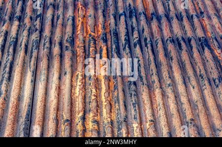 Farben und Konsistenz eines alten verrosteten Welleisendachs Stockfoto