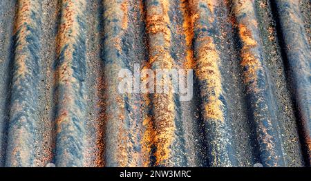 Farben und Konsistenz eines alten verrosteten Welleisendachs Stockfoto