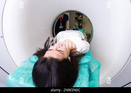 CT-Scan-MTRA überblickt Patienten im Computer-Tomographie-Scanner während der Vorbereitung des Verfahrens. Patientin, die in den CT-Scanner geht. Stockfoto