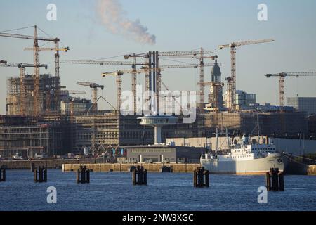 Hamburg, Deutschland. 06. Februar 2023. Die Kirche von St. Michaelis (Michel) ist zwischen den Kranen auf der Baustelle HafenCity zu sehen. Im Vordergrund liegt das Schiff "MS Stubnitz" in Baakenhafen, einem ehemaligen Kühl- und Transportschiff der Hochseefischerflotte der DDR, das heute als Veranstaltungsort genutzt wird. Auf der linken Seite sehen Sie den Kreuzfahrthafen Baakenhöft, einen alternativen Terminal für kleinere und mittelgroße Kreuzfahrtschiffe, und den weißen Turm „Lighthouse Zero“. Kredit: Soeren Stache/dpa/Alamy Live News Stockfoto