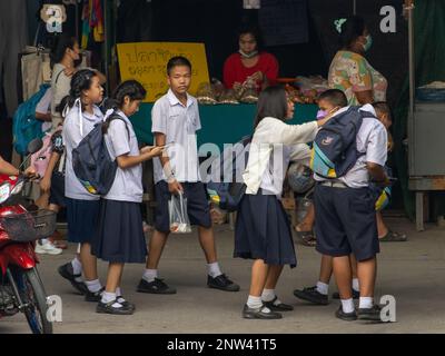 SAMUT PRAKAN, THAILAND, FEBRUAR 17 2023, Kinder in Schuluniformen spielen auf dem Heimweg von der Schule auf der Straße Stockfoto