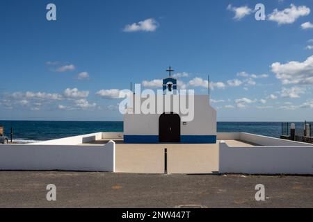 Kleine Kirche an der Ostküste des Atlantiks namens Ermita de la Virgen del Pino. Einfache Kombination aus Weiß und Blau. Glockenturm und Kreuz. Pue Stockfoto