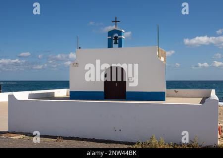 Kleine Kirche an der Ostküste des Atlantiks namens Ermita de la Virgen del Pino. Einfache Kombination aus Weiß und Blau. Glockenturm und Kreuz. Pue Stockfoto