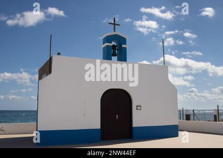 Kleine Kirche an der Ostküste des Atlantiks namens Ermita de la Virgen del Pino. Einfache Kombination aus Weiß und Blau. Glockenturm und Kreuz. Pue Stockfoto