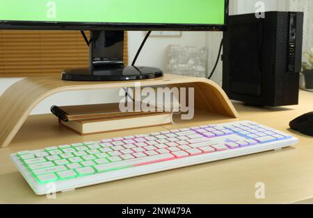 Moderne RGB-Tastatur auf Holztisch im Innenbereich Stockfoto