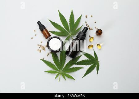 Flache Laienzusammensetzung mit Hanfblättern, CBD-Öl und THC-Tinktur auf hellem Hintergrund Stockfoto