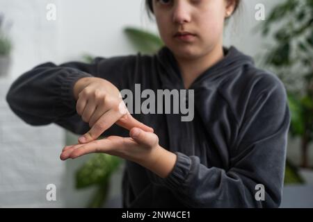 Taubstumme Mädchen mit Gebärdensprache auf hellen Hintergrund Cute Stockfoto