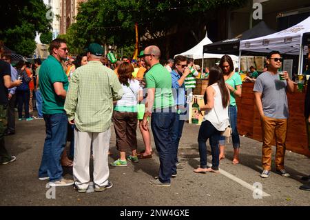 Freunde genießen es, beim St. Patrick's Day Festival in der Innenstadt von Los Angeles grün zu trinken und zu tragen Stockfoto