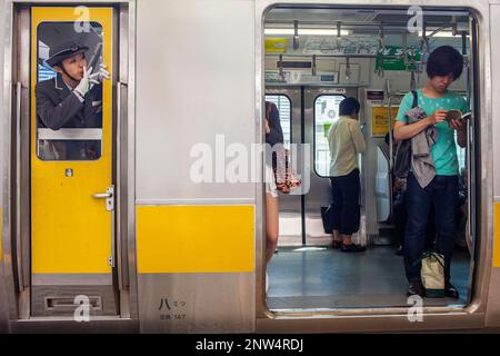 Zugführer und Passagiere. Bahnhof Shinjuku. Chuo Sobu Linie. Shinjuku, Tokio, Japan Stockfoto