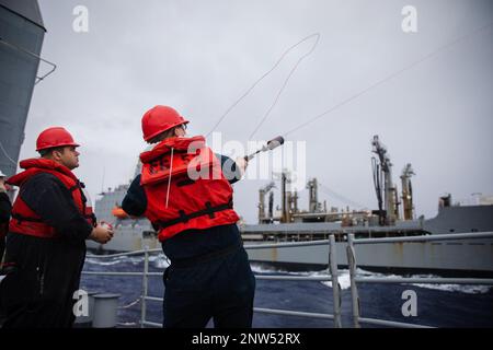 230114-N-YV347-1023 PHILIPPINE SEA (14. JANUAR 2023) USA Navy Gunner's Mate 3. Class James Ingebretson aus Seabeck, Washington, feuert eine Schusslinie ab vom Ticonderoga-Klasse-geführten Raketenkreuzer USS Bunker Hill (CG 52) bis zum Henry J. Kaiser-Klasse-Flottenöler USNS Guadalupe (T-AO 200). Bunker Hill, Teil der Nimitz Carrier Strike Group, gehört zur US-7.-Flotte und führt Routinevorgänge durch. 7. Fleet sind die USA Geburtsort: A) Bezirk Kandahar, Provinz Kandahar, Afghanistan; b) Bezirk Kandahar, Provinz Kandahar, Afghanistan; c) Bezirk Kandahar, Provinz Kandahar, Afghanistan. Stockfoto