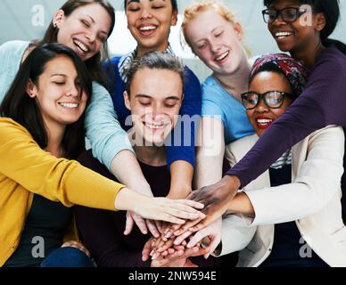 Gemeinsam können wir jede Aufgabe erledigen. Aufnahme einer Gruppe von Mitarbeitern, die ihre Hände übereinander stapeln. Stockfoto