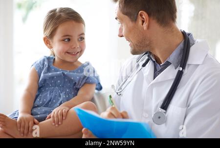 Wie fühlen Sie sich heute? Aufnahme eines hübschen männlichen Arztes mit einem entzückenden jungen Mädchen für einen Patienten. Stockfoto