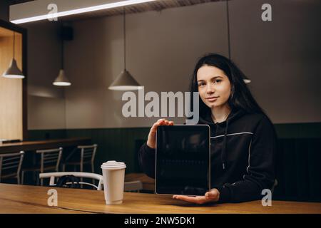 Schöne süße asiatische junge Geschäftsfrau im Café, mit digital-Tablette und trinken Kaffee lächelnd Stockfoto