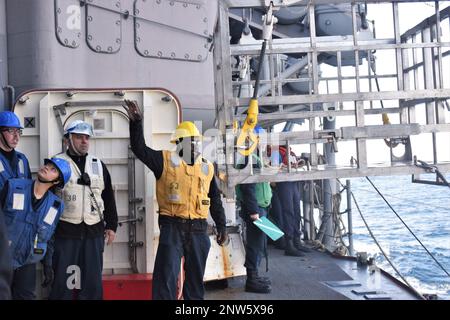 230126-N-TV933-2251 SEELEUTE DER PHILIPPINEN SEE (26. Januar 2023) an Bord des Ticonderoga-Klasse-Guided-Missile Cruiser USS Antietam (CG 54) koordinieren die Rückgabe eines Frachtcontainers an das japanische Schiff JS Oumi (AOE 426) der Mashu-Klasse zur Wiederauffüllung auf See. Antietam führt derzeit Routineeinsätze durch, die die Bereitschaft zur Kriegsführung und die Interoperabilität der Verbündeten erhöhen. Stockfoto