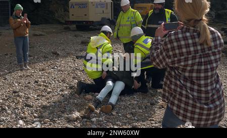 Strandprotester wurde von der Sicherheitsabteilung am Cornish Beach UK geschleppt Stockfoto