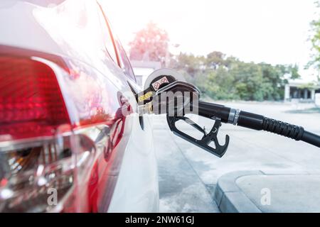 Nahaufnahme Detailansicht des schwarzen Pistolengriffs, der in den weißen Dieselkraftstofftank der Tankstelle eingesetzt wurde. Self-Service und Wartung Stockfoto