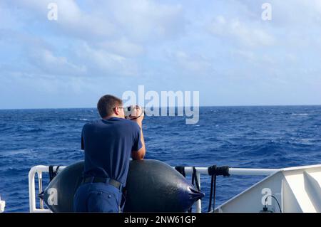 Die Besatzung der USCGC Myrtle Hazard (WPC 1139) sucht am 9. Februar 2023 auf halber Strecke zwischen Guam und Rota nach einem Seefahrer, der von einer Guam Army National Guard UH-72 Lakota Hubschraubercrew, die die Trümmer ursprünglich fand, ins Trümmerfeld verbannt wurde. Die Crew reagierte auf einen Notruf vom Kapitän des 42-Fuß-Schiffs Senor Dung am 8. Februar zusammen mit anderen bundesstaatlichen und lokalen Einsatzkräften. Stockfoto