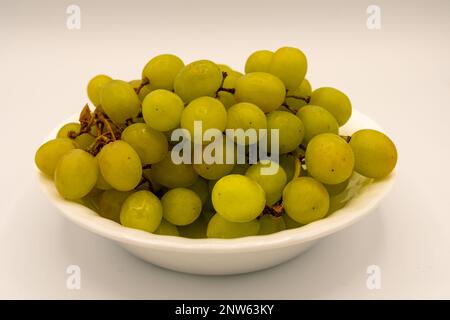 Eine Schüssel mit grünen Trauben auf weißem Hintergrund. Stockfoto