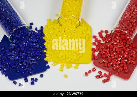 Blaue, gelbe und rote Kunststoffharze in Reagenzgläsern im Labor mit farbigen Probenplatten Stockfoto