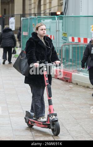 Birmingham, 28. Februar 2023 - Eine Frau fährt am letzten Tag vor Einstellung des Betriebs legal einen VOI-Elektroroller. - VOI Scooter, die einzige Mietwagenfirma in Birmingham, wird ihren Betrieb am Dienstag, den 28. Februar, um 11pm Uhr einstellen. Die Elektroroller waren in Englands zweiter Stadt bereits dünn auf dem Boden, nachdem das Unternehmen sagte, sie würden die Fahrzeuge in den nächsten Wochen entfernen. Das Unternehmen mietete Motorroller für einen Testzeitraum, hat sich jedoch entschieden, den Vertrag nicht fortzusetzen, und kein anderes Unternehmen hat die freie Stelle besetzt. Abst Stockfoto