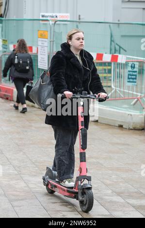 Birmingham, 28. Februar 2023 - Eine Frau fährt am letzten Tag vor Einstellung des Betriebs legal einen VOI-Elektroroller. - VOI Scooter, die einzige Mietwagenfirma in Birmingham, wird ihren Betrieb am Dienstag, den 28. Februar, um 11pm Uhr einstellen. Die Elektroroller waren in Englands zweiter Stadt bereits dünn auf dem Boden, nachdem das Unternehmen sagte, sie würden die Fahrzeuge in den nächsten Wochen entfernen. Das Unternehmen mietete Motorroller für einen Testzeitraum, hat sich jedoch entschieden, den Vertrag nicht fortzusetzen, und kein anderes Unternehmen hat die freie Stelle besetzt. Abst Stockfoto