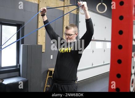 USA Army Reserve Sgt. 1. Klasse David Culpepper, der Hauptquartier und Hauptquartier zugewiesen wurde, 88. Readiness Division, Fort McCoy, Wisconsin, zieht Bands an, um sich in einem Cross-Fit-Fitnessstudio in Sparta, Wisconsin, zu strecken, 8. Januar 2023. Das Training war eine Partnerschaft mit der Sparta-Einrichtung und Teil der ganzheitlichen Umsetzung der Abteilung Gesundheit und Fitness. Stockfoto