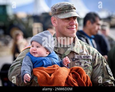 Edgar Soto, Stabschef der Arizona Army National Guard, von der 860. Military Police Company, verbringt Zeit mit seinem 7 Monate alten Sohn Ezekiel nach einer Abschiedszeremonie für seine Einheit am 17. Februar 2023 im Valencia Armory in Tucson, Arizona Staff Sgt. Edgar und etwa 65 weitere Soldaten der Kompanie 860. MP, 850. Bataillon, sollen für 9 Monate nach Kuwait zur Unterstützung der Operation Spartan Shield entsandt werden. (Fotos der Arizona Army National Guard von Sergeant 1. Klasse Brian A. Barbour) Stockfoto