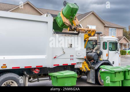 Horizontaler Schuss des mechanischen Arms auf einem modernen Müllwagen, der Müll ohne Hilfe entsorgt. Stockfoto