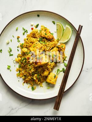 Gelbes gebratenes Curry-Reisgericht mit Huhn, Koriander, Chili und Gewürzen. Thai-saure und würzige Gerichte. Stockfoto