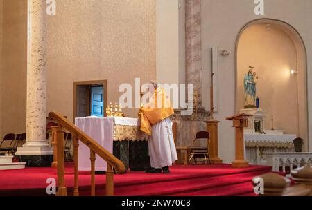 Diakon hält eine Monstrance vor dem Altar im Heiligtum der Basilika St. Die katholische Kirche Stanislaus in Winona, Minnesota, USA. Stockfoto