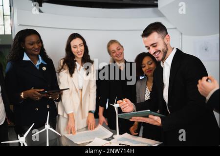 Multikulturelle Gruppe von Ingenieuren, die gemeinsam an einem neuen Projekt für erneuerbare Energien arbeiten. Stockfoto