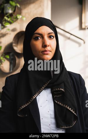 Vertikales Porträt einer arabischen Frau mit Schleier, der in die Kamera schaut. Stockfoto