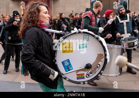 Berlin, Deutschland 3/8/2020 Eine Frau mit einer Basstrommel marschiert und spielt während des Protests zum Internationalen Frauentag, der Demonstration zum 8M. Kampftag Stockfoto