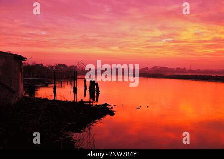 Dramatischer Himmel im Sumpf in der Nähe einer Fischerhütte (Pialassa dei Piomboni) Stockfoto